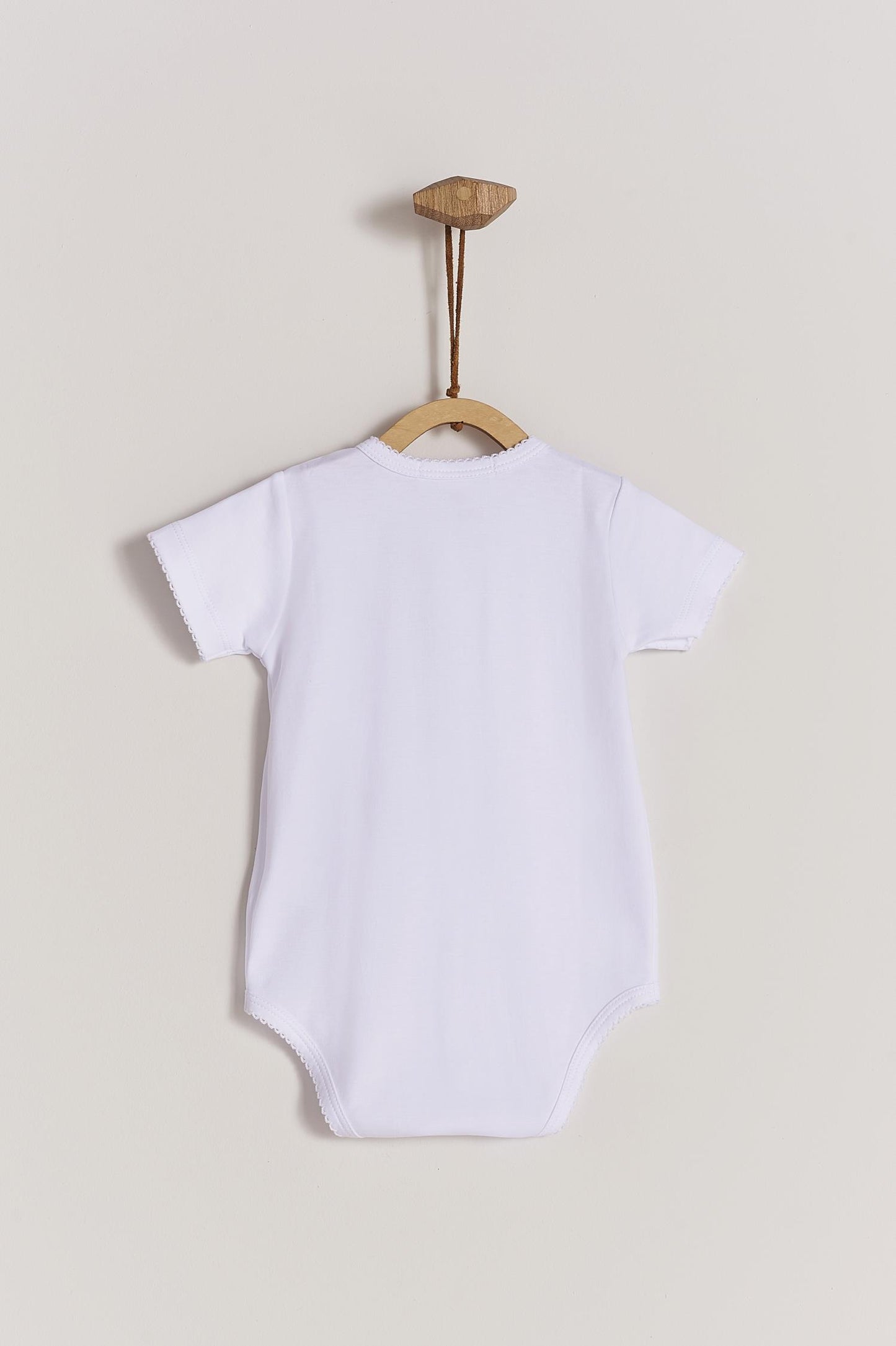 This baby basic short sleeve snapped bodysuit made with 100% super soft and resistant Pima cotton is a must have for your little one. Features a delicate embroidered neckline and sleeves alongside our cute logo bunny embroidered at chest. A baby's wardrobe essential! Popper fastenings around the legs and the front make changing easy, too. Colour: White. Composition: 100% Peruvian Pima Cotton. Made in Peru. Machine washable.