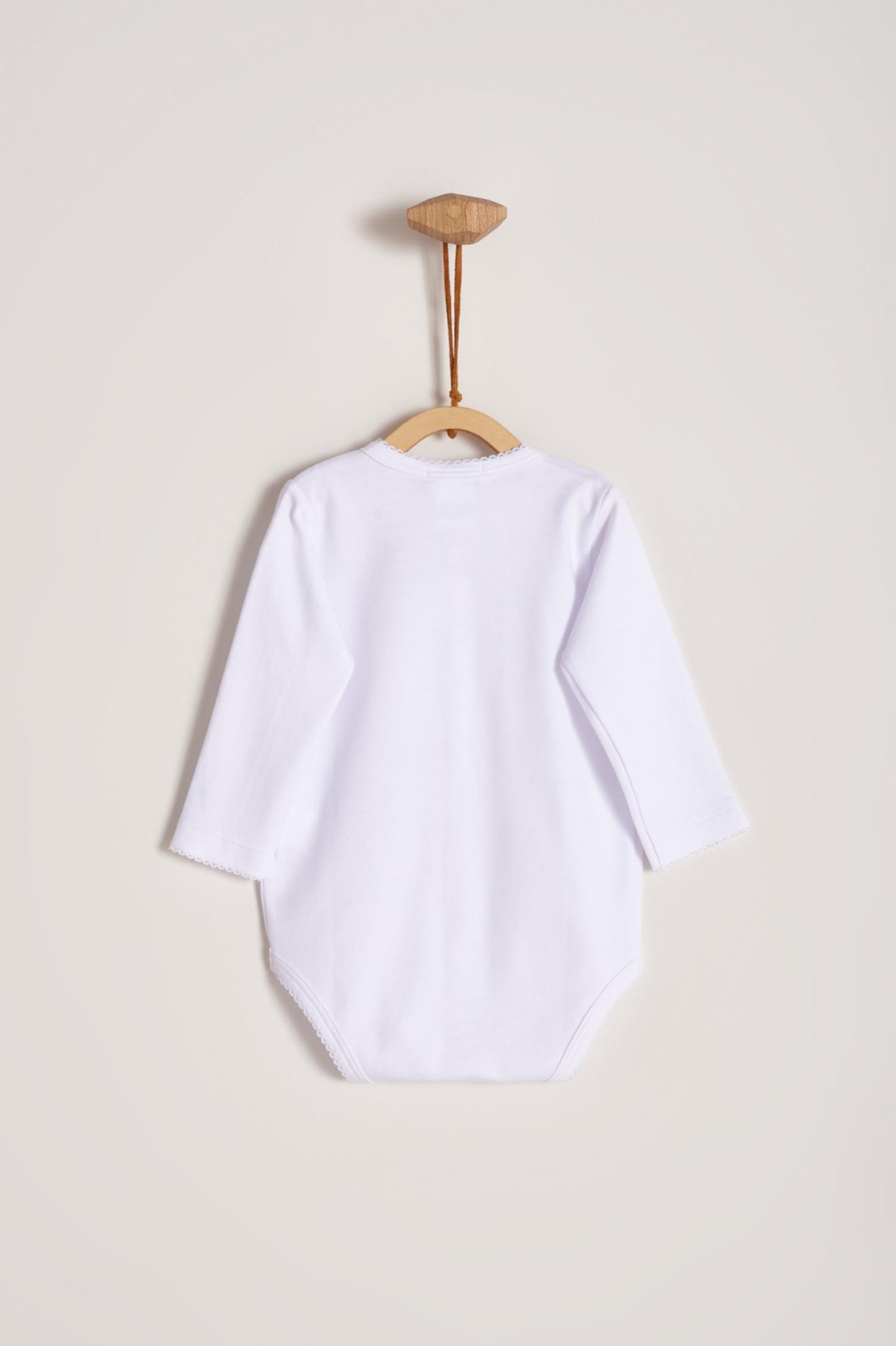 This baby basic long sleeve snapped bodysuit made with 100% super soft and resistant Pima cotton is a must have for your little one. Features a delicate embroidered neckline and sleeves alongside our sweet logo bunny. A baby's wardrobe essential! Popper fastenings around the legs and the front make changing easy, too. Colour: White. Composition: 100% Peruvian Pima Cotton. Made in Peru. Machine washable.
