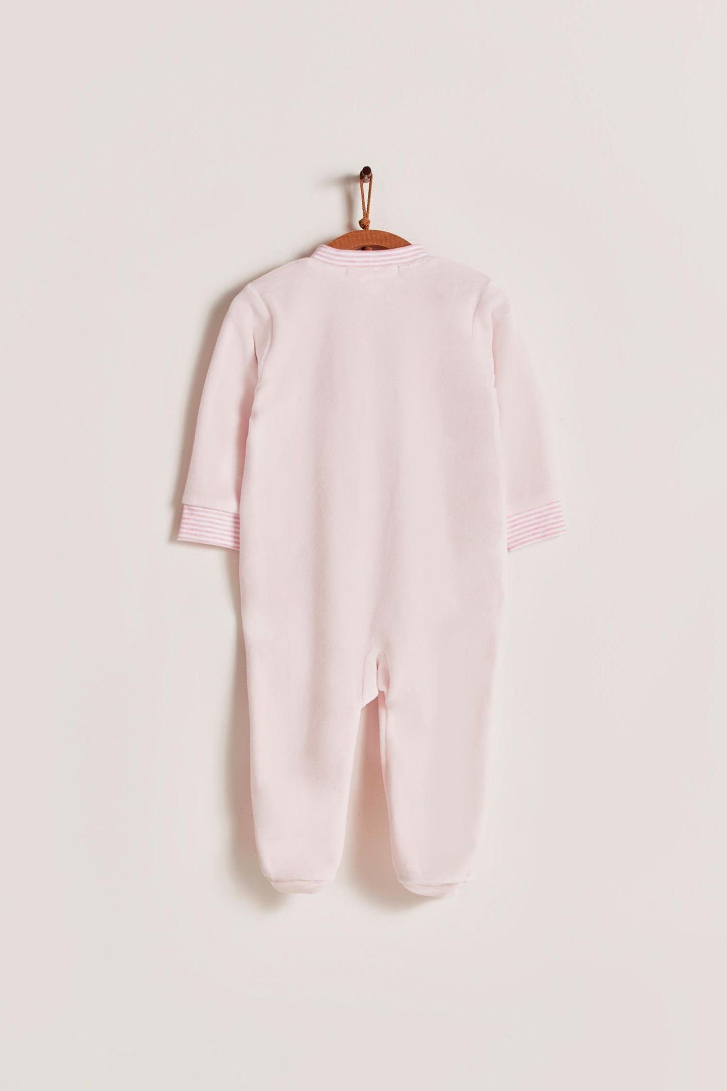 Super warm and soft plush pyjama, ideal to stay warm and comfortable during winter! With long-sleeves, footed and with front closure. Features a lovely striped ribbed collar and cuffs, alongside an embroidered patch on the front. Colour: Pink. Composition: 85% Peruvian Pima cotton, 15% polyester. Made in Peru. Machine washable. Safety warning: Keep away from fire.