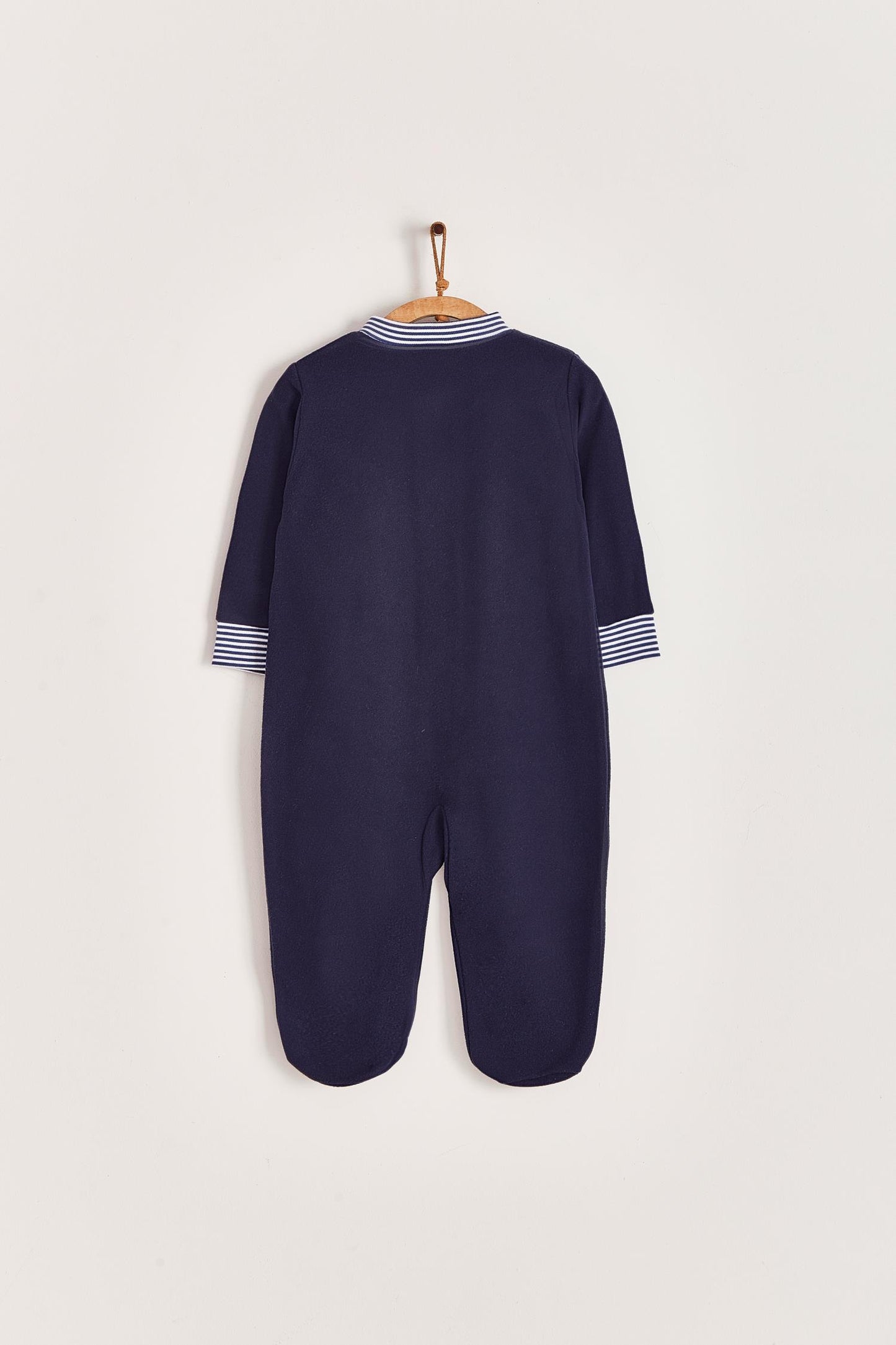 Super warm and soft polar fleece pyjama, ideal to stay warm and comfortable during winter! With long-sleeves, footed and with front closure. Features a lovely striped ribbed collar and cuffs, alongside an embroidered patch on the front. Colour: Blue Composition: 100% Peruvian Pima Cotton. Made in Peru. Machine washable. Safety warning: Keep away from fire.