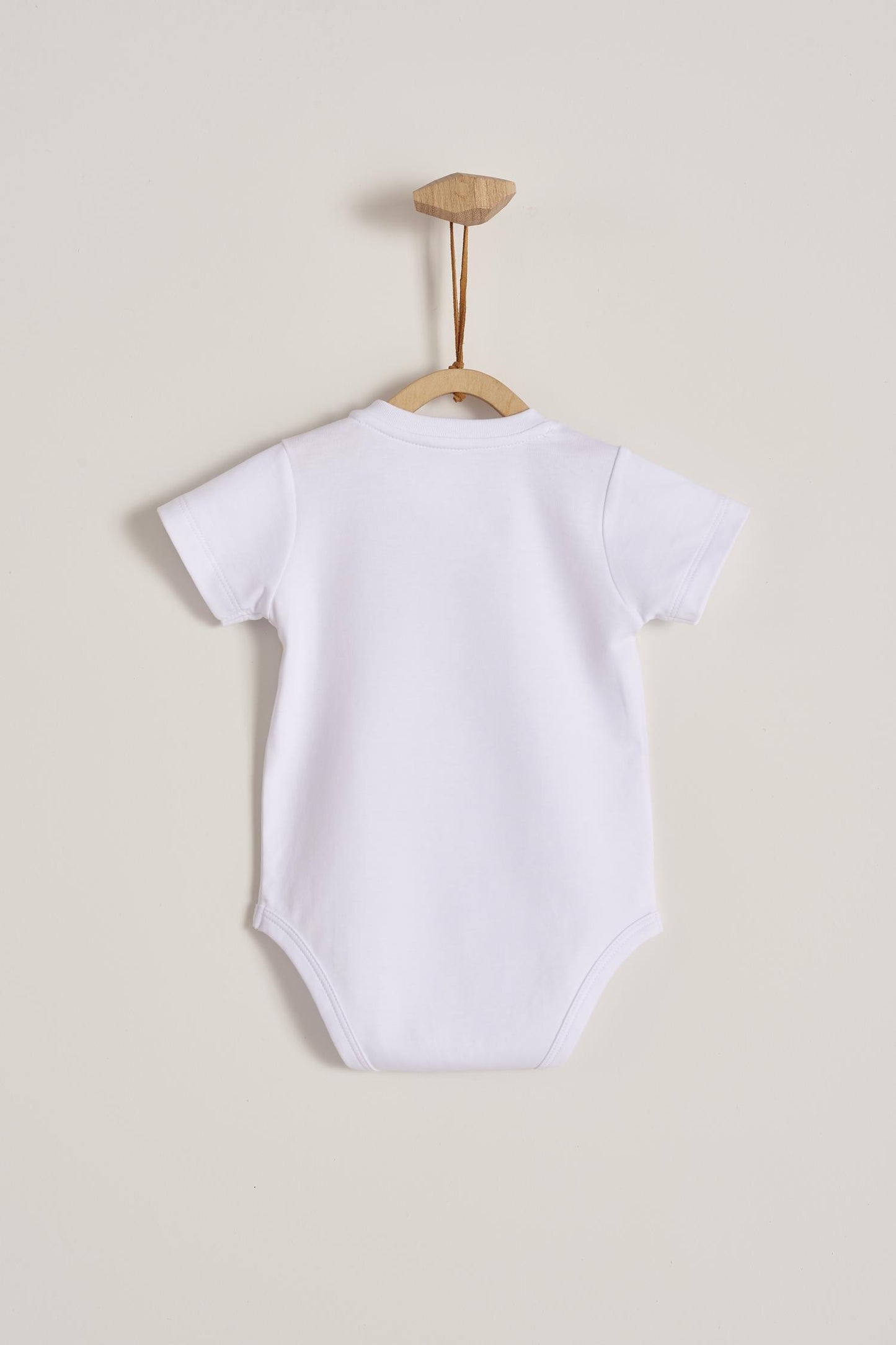 Pima cotton, long-sleeved, t-shirt collar bodysuit. Perfect for a casual look! Poppers on the shoulder and crotch: handy when getting baby dressed. A baby's wardrobe essential! Colour: White. Composition: 100% Peruvian Pima Cotton. Made in Peru. Machine washable.