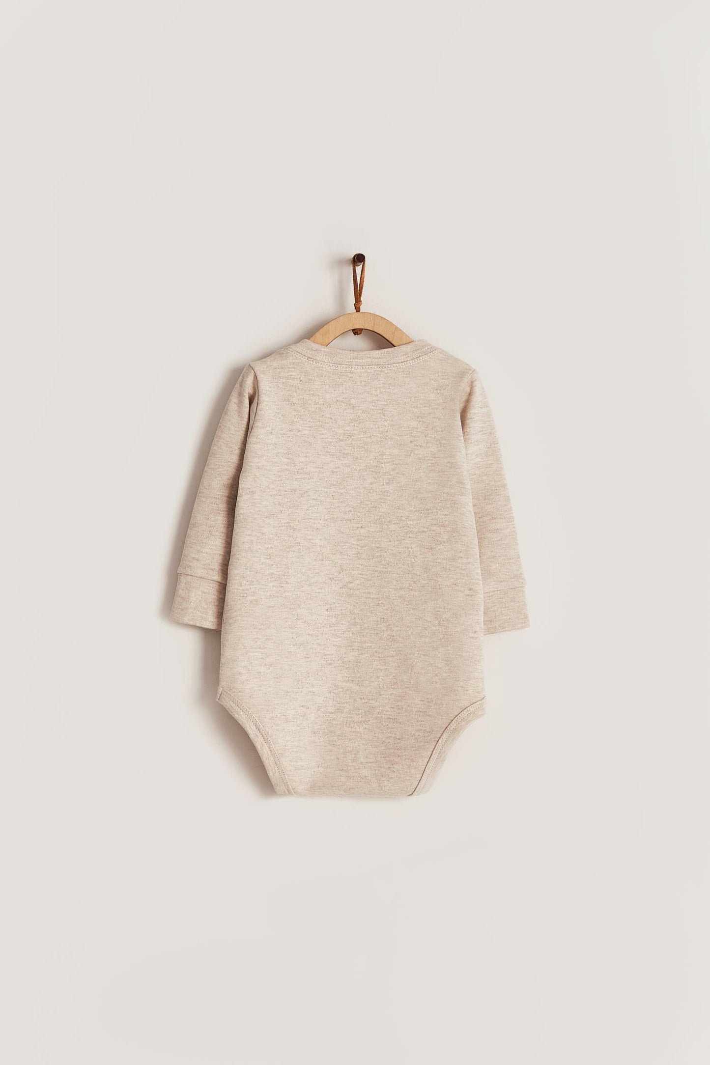 Pima cotton, long-sleeved, t-shirt collar bodysuit. Perfect for a casual look! Poppers on the shoulder and crotch: handy when getting baby dressed. A baby's wardrobe must-have available in a range of colours. Colour: Beige melange. Composition: 100% Peruvian Pima Cotton. Made in Peru. Machine washable.