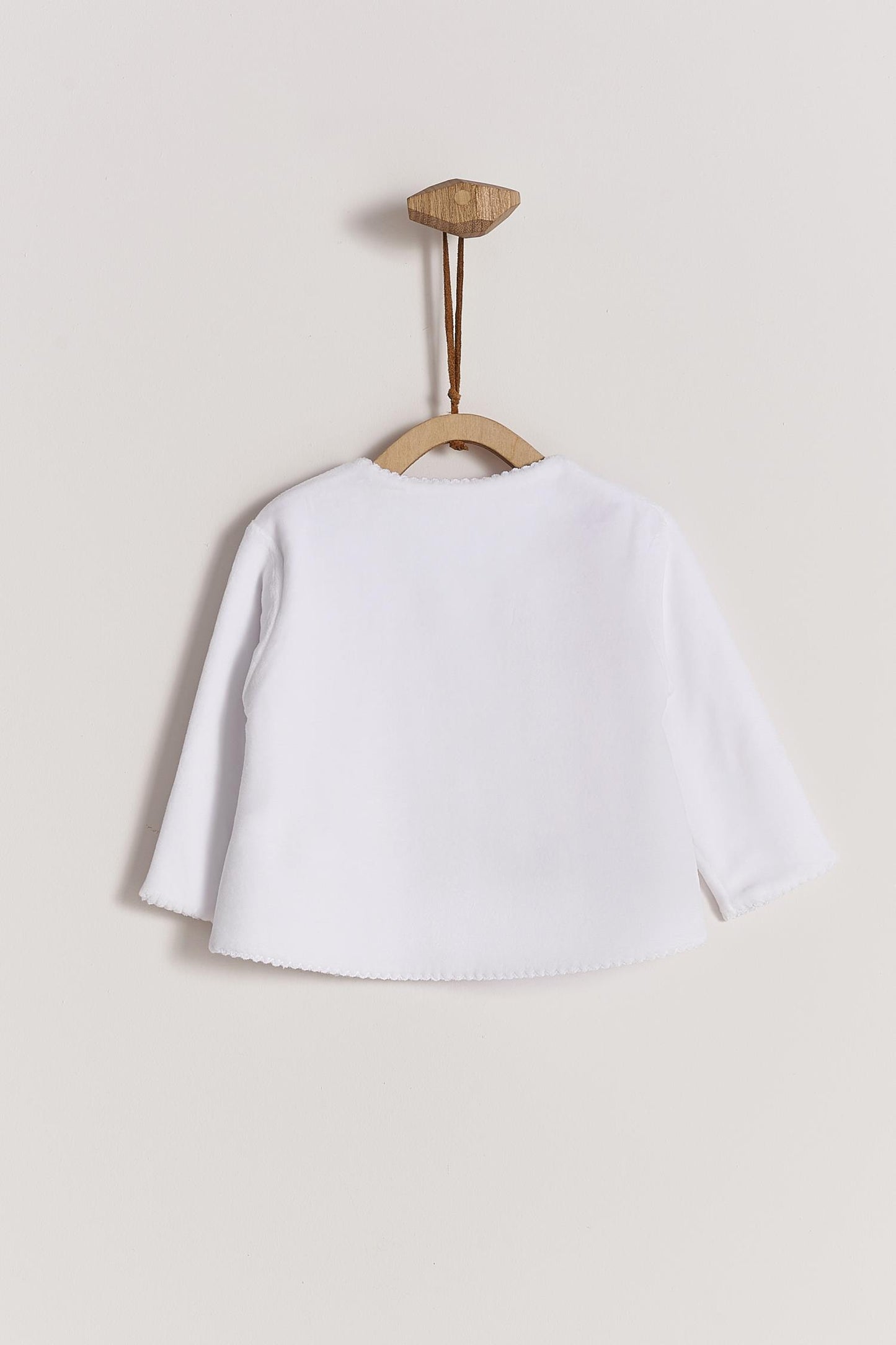 Super soft plush fabric that keeps your baby comfortable and warm. A perfect cardigan for those chilly nights! Featuring a delicate embroidered lining along the neckline and 3 buttons at the top. Pair it with our plush pants for the sweetest look and perfect gift! Colour: White. Composition: 100% Peruvian Pima cotton , 15% Polyester. Made in Peru. Machine washable.