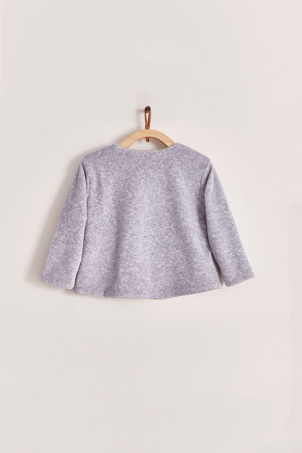 Super soft plush fabric that keeps your baby comfortable and warm. A perfect cardigan for those chilly nights! Featuring a delicate embroidered lining along the neckline and 3 buttons at the top. Pair it with our plush pants for the sweetest look and perfect gift! Colour: Grey. Composition: 100% Peruvian Pima cotton , 15% Polyester. Made in Peru. Machine washable.