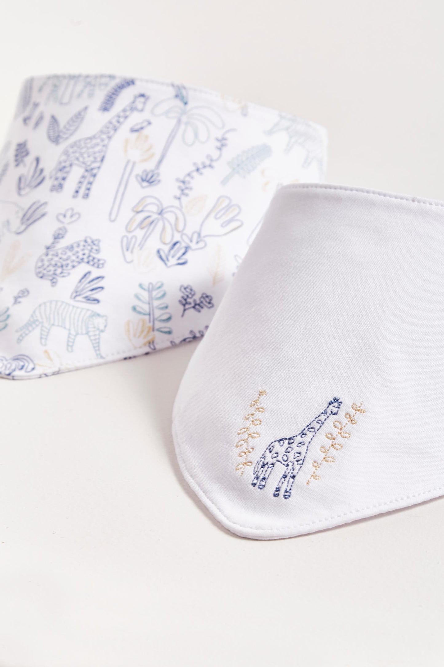 This set of 2 bandana style bibs is perfect to fit your baby from 0 to 6 months. It not only helps to keep teething baby dry and neat, but is also versatile enough for any daily outfit. One comes with an embroidered giraffe and the second one comes with full print of the collection The reverse side has an absorbent towel for an extra comfort. Composition: 100% Peruvian Pima Cotton. Made in Peru. Machine washable.