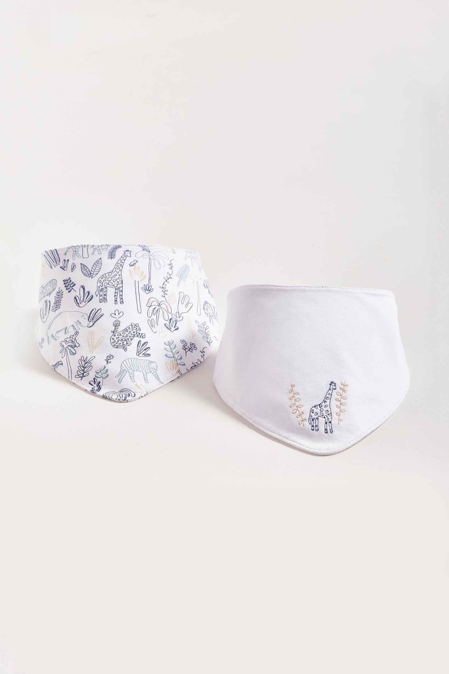 This set of 2 bandana style bibs is perfect to fit your baby from 0 to 6 months. It not only helps to keep teething baby dry and neat, but is also versatile enough for any daily outfit. One comes with an embroidered giraffe and the second one comes with full print of the collection The reverse side has an absorbent towel for an extra comfort. Composition: 100% Peruvian Pima Cotton. Made in Peru. Machine washable.