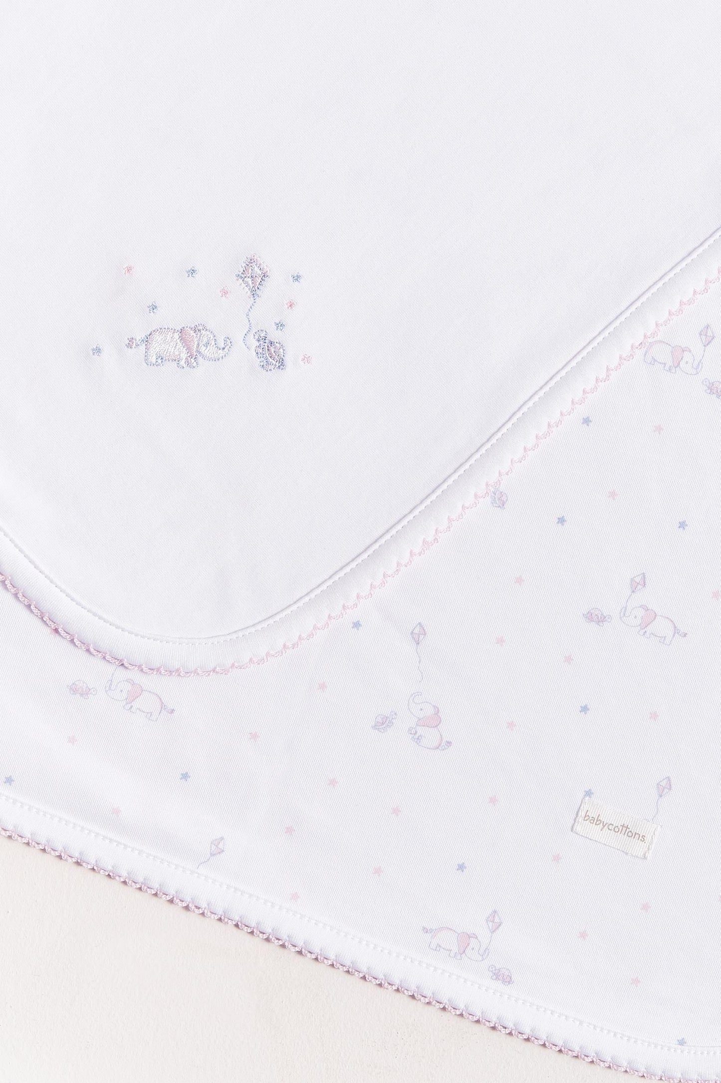 Crafted from super soft Pima cotton, this receiving blanket makes babies first months extra cozy. This two sided blanket features a sleek white finish with an embroidered of Celine & Bernie, while the other side comes with a full print of our Celine & Bernie collection. Composition: 100% Peruvian Pima Cotton. Made in Peru. Machine washable.