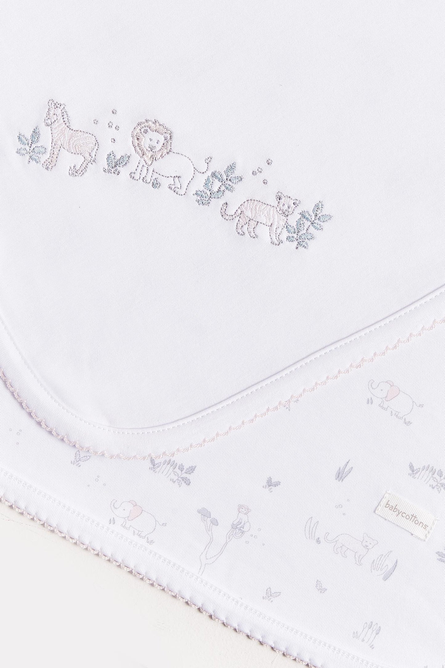 Crafted from super soft cotton, this receiving blanket makes babies first months extra cozy. This two sided blanket features a sleek white finish with embroidered jungle animals, while the order side comes with a full print of our Mini Safari collection. Approximate measurements: 100 cm x 100 cm Composition: 100% Pima Cotton. Made in Peru. Machine washable.