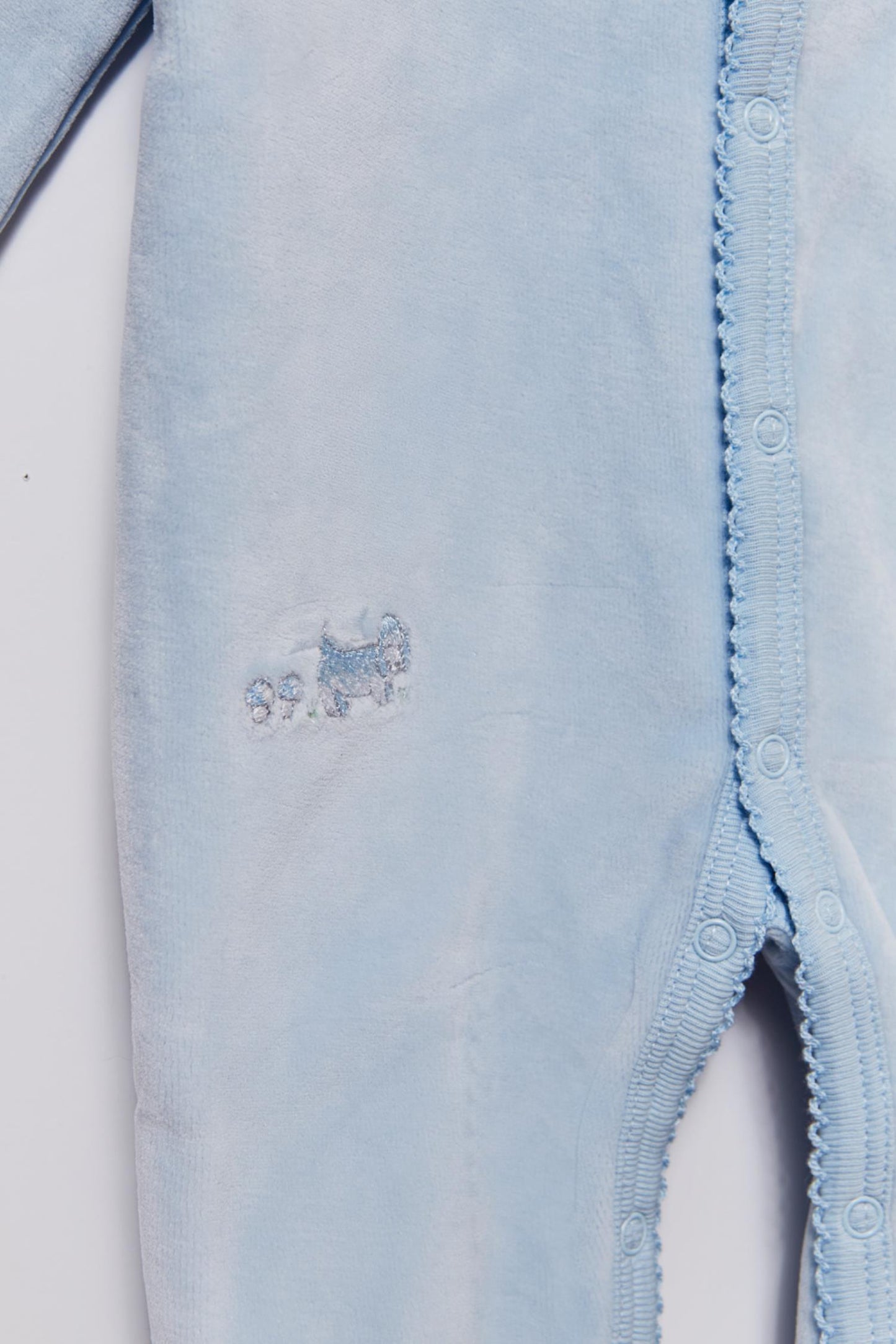 Super soft and warm plush footie for your little baby's first winter. Fully lined with our cute In the Woods 100% Pima cotton print. Features long sleeves, rounded neckline and embroidery at the front with full snaps closure or easy dressing and diapering. Match it with our logo blanket and beanie for the ideal gift! Colour: Light-blue. Composition: Outer: 85% cotton, 15% polyester. Lining: 100% Pima cotton.  Made in Peru. Machine wash cold.