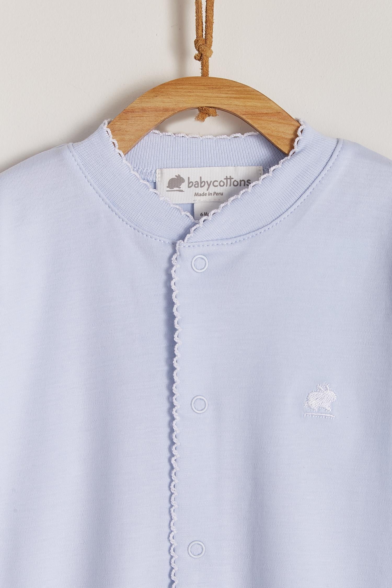 Essential footie made 100% with the softest Peruvian Pima Cotton. One of our most popular items!  Long sleeves, crew neckline and full snap opening.  Newborn footies (NB) come with reversible cuffs that help prevent scratching. Match with any of our blankets, bibs and newborn hats for the perfect gift! Colour: Light-blue Composition: 100% Peruvian Pima Cotton.  Made in Peru. Machine washable. Safety warning: Keep away from fire.