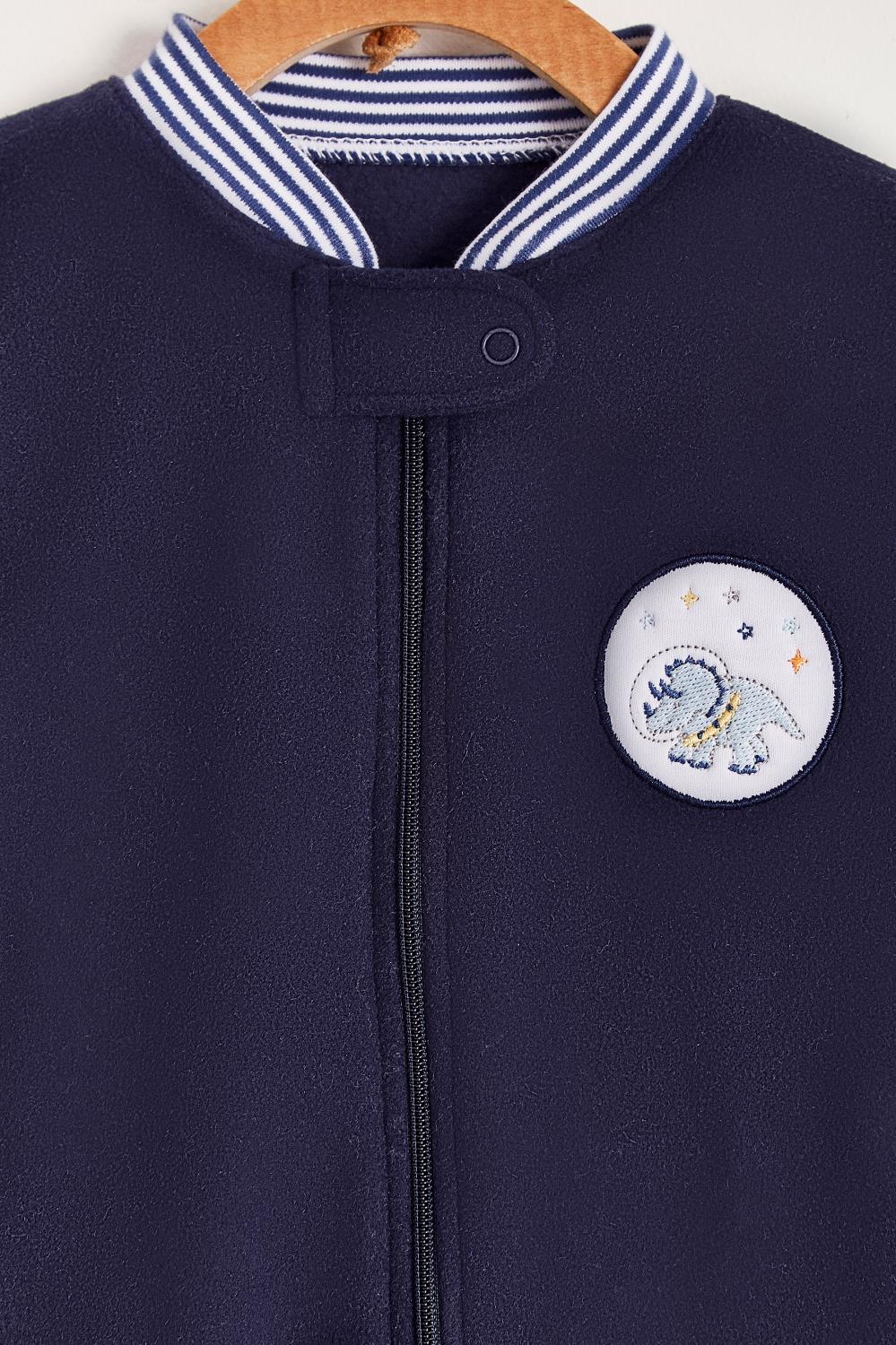 Super warm and soft polar fleece pyjama, ideal to stay warm and comfortable during winter!  With long-sleeves, footed and with front closure.  Features a lovely striped ribbed collar and cuffs, alongside an embroidered patch on the front.  Colour: Blue Composition: 100% Peruvian Pima Cotton.  Made in Peru. Machine washable. Safety warning: Keep away from fire.