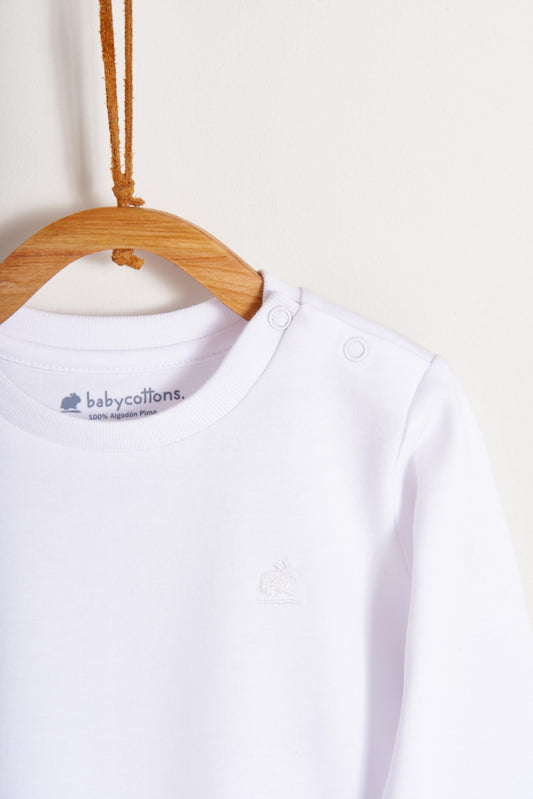 Pima cotton, long-sleeved, t-shirt collar bodysuit. Perfect for a casual look! Poppers on the shoulder and crotch: handy when getting baby dressed. A baby's wardrobe must-have available in a range of colours.  Colour: White. Composition: 100% Peruvian Pima Cotton.  Made in Peru. Machine washable.