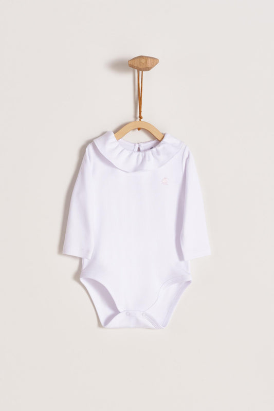 Made from 100% super soft Pima cotton. Long sleeves bodysuit, with cute ruffle collar around.  A classic must have! Popper fastenings around the legs and the back make changing easy, too. Colour: White. Composition: 100% Peruvian Pima Cotton.  Made in Peru.  Machine washable. 
