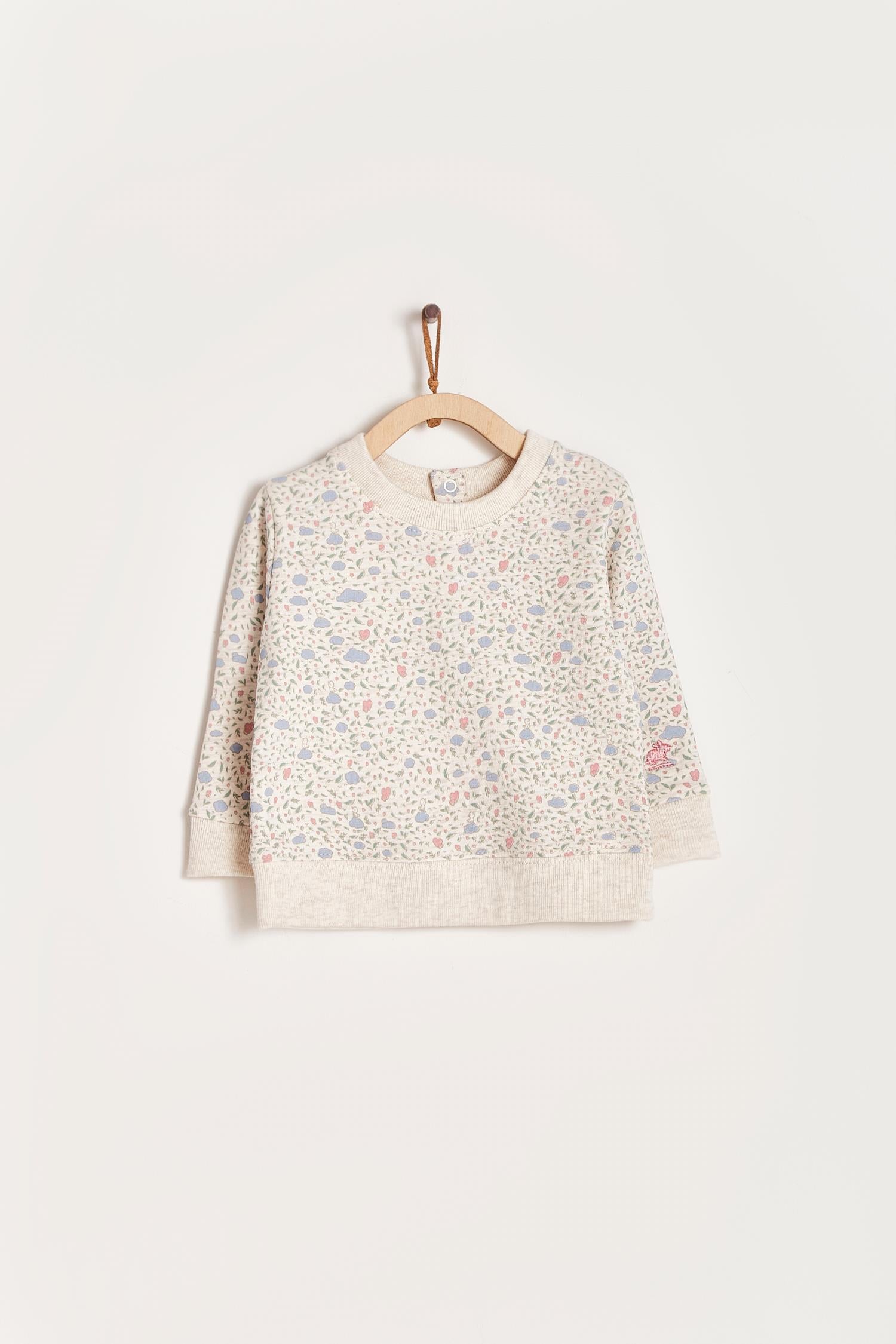 Keep your little one warm and comfortable with our baby sweatshirt, fully printed with our cutest Fall in Love print. Round neckline and snaps closure at the back. Match it with our Fall in Love pants for the sweetest look! Colour: Beige melange with pink and light-blue details. Composition: 100% Peruvian Pima cotton.  Made in Peru. Machine wash cold. 