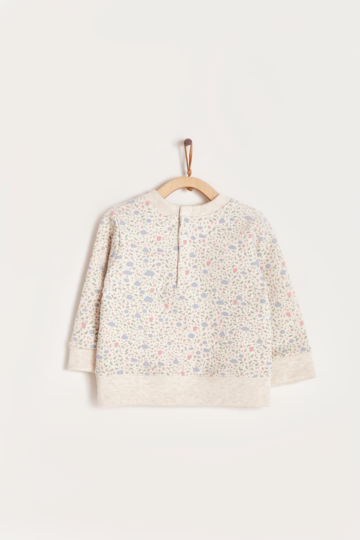 Keep your little one warm and comfortable with our baby sweatshirt, fully printed with our cutest Fall in Love print. Round neckline and snaps closure at the back. Match it with our Fall in Love pants for the sweetest look! Colour: Beige melange with pink and light-blue details. Composition: 100% Peruvian Pima cotton.  Made in Peru. Machine wash cold. 