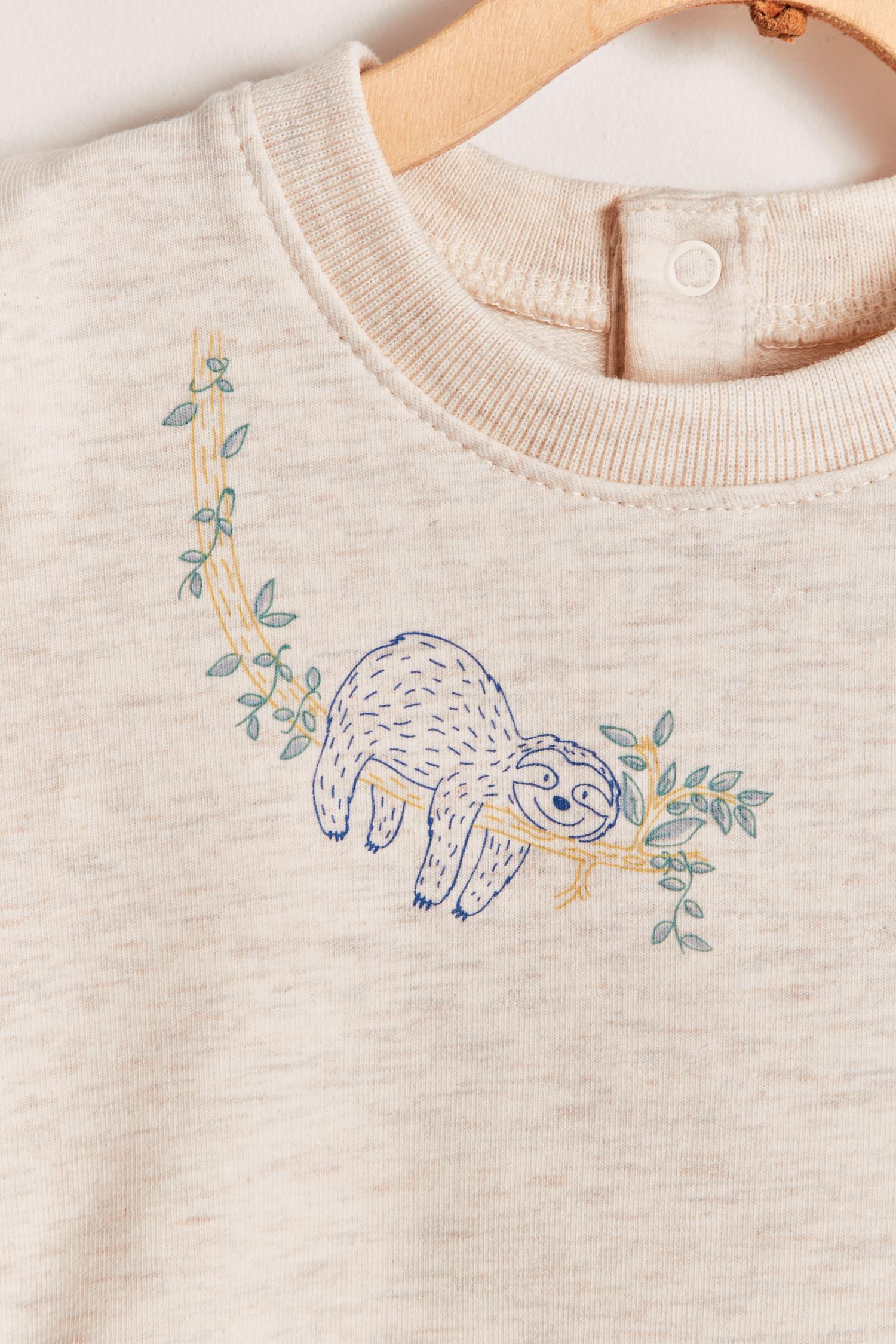 Keep your little one warm and comfortable with our baby sweatshirt, fully printed with our cute Safari collection. Round neckline and snaps closure at the back. Match it with any of our pants for the sweetest look and the perfect gift! Colour: Beige melange with blue and green details. Composition: 100% Peruvian Pima cotton.  Made in Peru. Machine wash cold. 