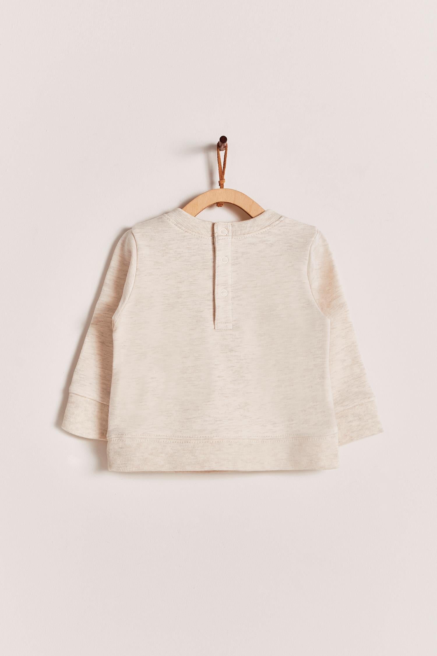Keep your little one warm and comfortable with our baby sweatshirt, fully printed with our cute Safari collection. Round neckline and snaps closure at the back. Match it with any of our pants for the sweetest look and the perfect gift! Colour: Beige melange with blue and green details. Composition: 100% Peruvian Pima cotton.  Made in Peru. Machine wash cold. 