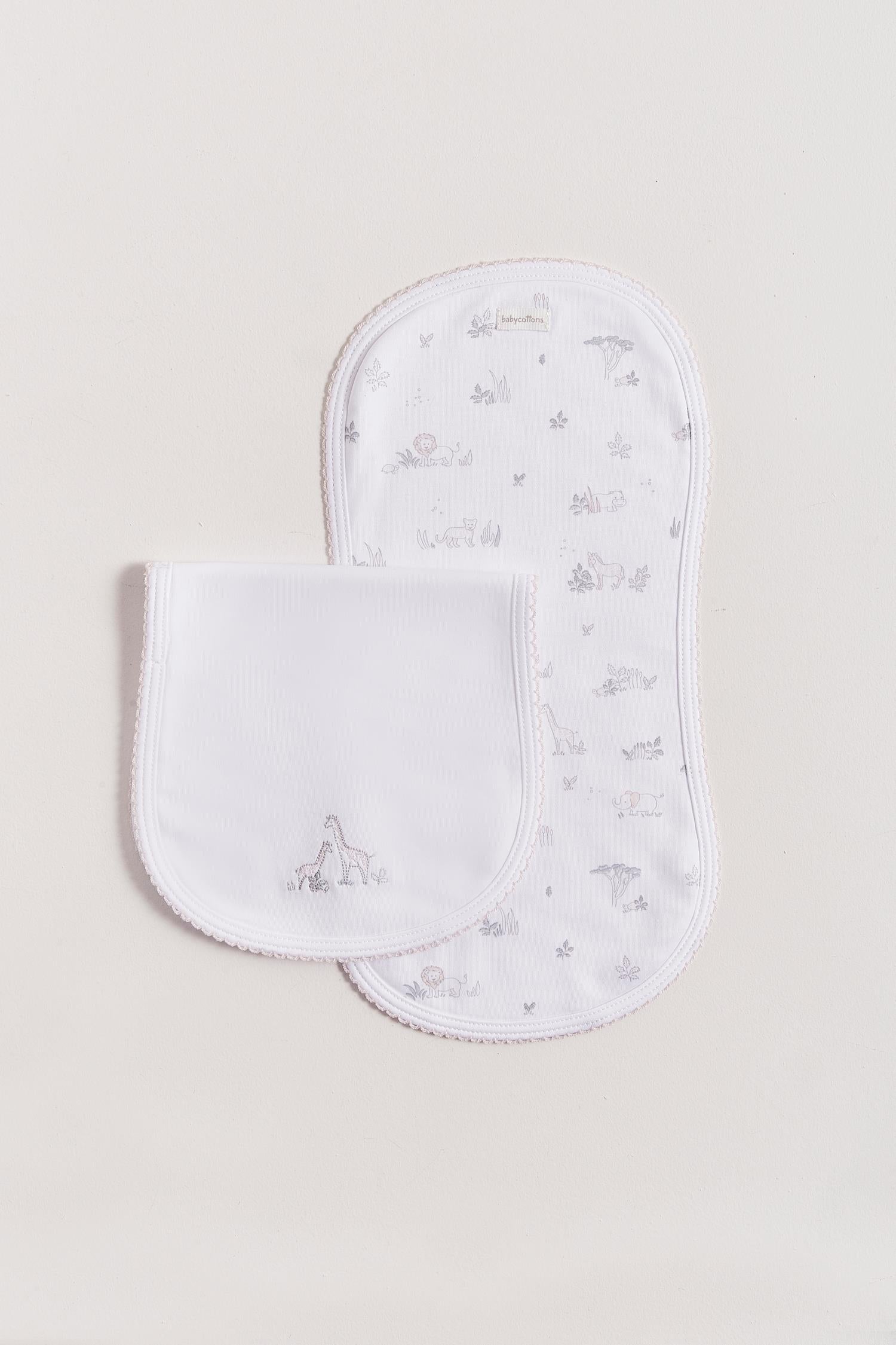 Protect your clothes after feeding with this set of two cute and ultra soft burp clothes!  Two Pima cotton burp clothes of approx. 18 cm x 36 cm, one with our Mini Safari print and the other one plain white with embroidered giraffes.  Reverse side has absorbent towel for extra comfort. This product is a MUST have! Composition: 100% Pima Cotton.  Made in Peru.  Machine washable. 