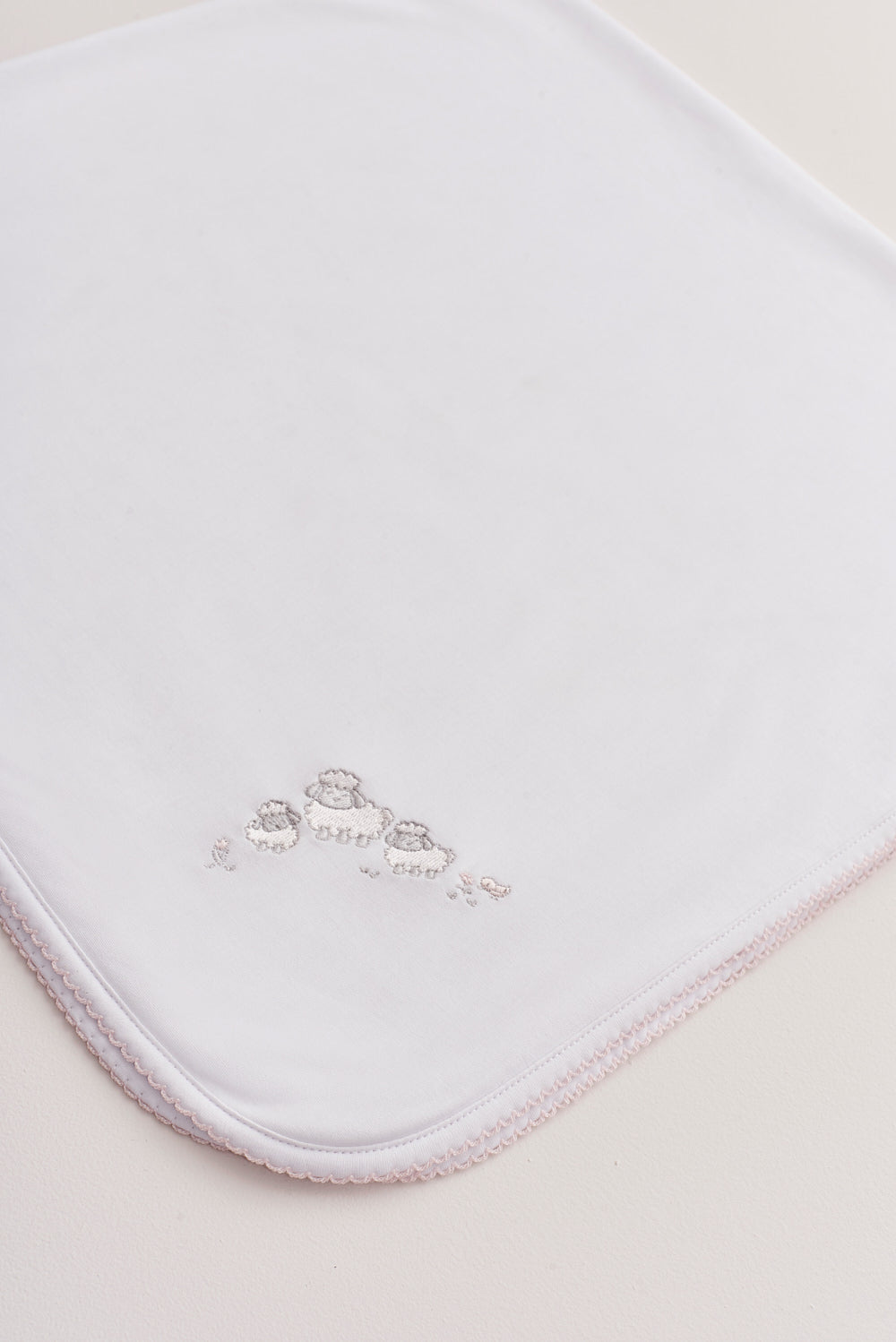 Crafted from super soft Pima cotton, this receiving blanket makes babies first months extra cozy. This two sided blanket features a sleek white finish with an embroidered Fluffy Sheep, while the other side comes with a full print of our lovely Fluffy Sheep collection. Approximate measurement: 100 cm x 100 cm. Composition: 100% Peruvian Pima Cotton.  Made in Peru.  Machine washable. 