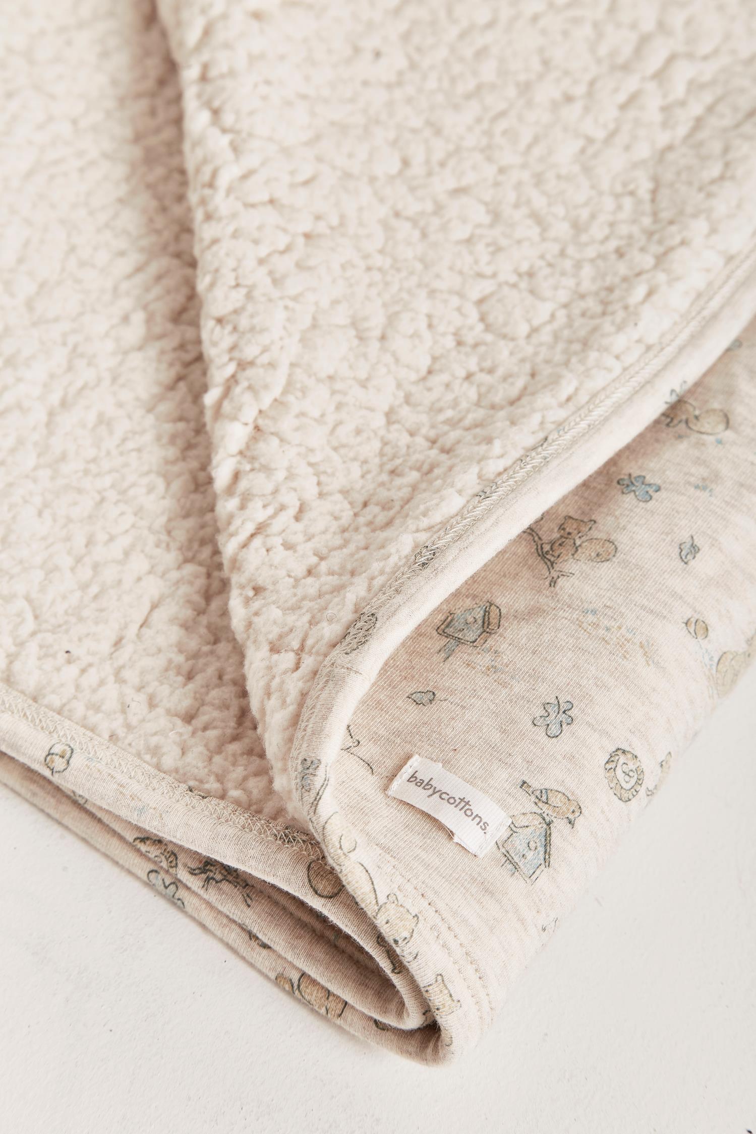 Perfect for keeping your little one cosy and warm on a chilly evening, this sherpa blanket features our little pet Odette print. Its french terry fabric is irresistibly soft and super comfy. Measures approx.: 70 cm x 72 cm. Made in Peru. Machine washable.